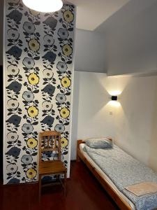 a bedroom with a wall with a bed and a chair at Hostel Retro in Kraków