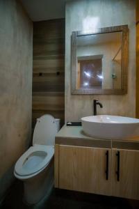 een badkamer met een wit toilet en een wastafel bij Entire place with pool and bar16pax accomdtn in Bacolod