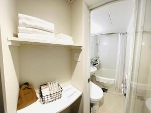 un piccolo bagno con un water e un lavandino di Kamon Hotel Namba ad Osaka
