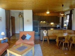 a living room with a couch and a table and a kitchen at Les RHODOS 3 in Les Crosets