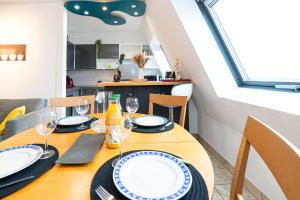 uma sala de jantar com uma mesa com pratos e copos de vinho em * * Le Duplex des Cigognes * * em Hoenheim