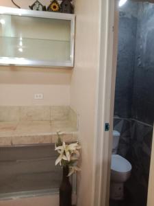 a bathroom with a toilet and a vase with a flower at TerisitaPlace - LoveAtFirst in Taytay +7 photos