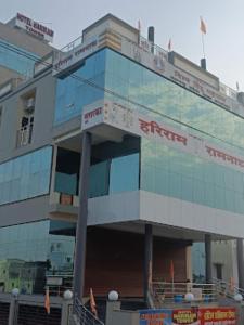 a large glass building with a sign on it at Hotel Hariram Tower,Wardha in Wardha