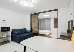 a living room with a couch and a chair at Jeju Seomun Residence Hotel in Jeju