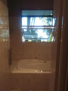 a bath tub in a bathroom with a window at Blue Oasis in Benoni