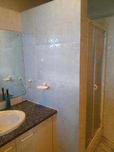 a bathroom with a glass shower and a sink at Blue Oasis in Benoni