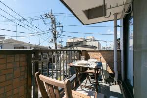 a balcony with a table and chairs on a balcony at Shinkoiwa Sta 5min!  Free Wi-Fi! Max 5 people. in Tokyo