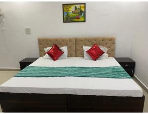 - un lit avec des oreillers rouges et blancs dans l'établissement Hotel Subh Ratri, Jhansi, à Jhansi