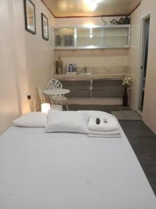 a white bed in a room with a kitchen at TerisitaPlace - LoveAtFirst in Taytay