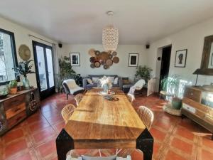 a living room with a wooden table and chairs at Villa La Ressourcerie a Saignon in Saignon