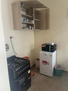 a small kitchen with a stove and a refrigerator at Lux Suites Narok Holiday Homes in Narok