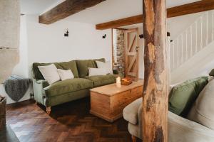 een woonkamer met een groene bank en een tafel bij Lodge Cottage, Castleton in Castleton
