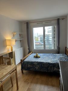 um quarto com um urso de peluche sentado numa cama em Appartement Créteil proche Métro em Créteil