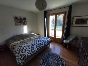 a bedroom with a bed and a large window at Villa La Ressourcerie a Saignon in Saignon