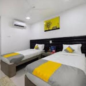1 dormitorio con 2 camas de color amarillo y gris en La Riviera Suites Madhapur en Hyderabad