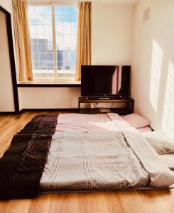 a large bed in a room with a large window at Warm House 5 in Sapporo