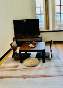 a living room with a table and chairs and a television at Warm House 5 in Sapporo