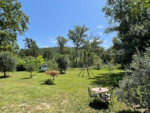 a table and chairs in a field with a telescope at Villa La Ressourcerie a Saignon in Saignon