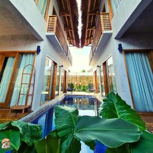 a house with a swimming pool with large green plants at Luna Tres Homestay Siargao in General Luna