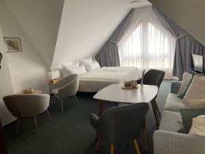 una camera d'albergo con letto, tavolo e sedie di Pension am Markt a Lübben