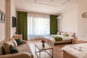 een hotelkamer met 2 bedden en een bank bij New Tiflis Apartment Mziuri in Tbilisi City
