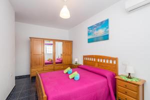 A bed or beds in a room at Lightbooking Gadi House Tasarte terraza y barbacoa