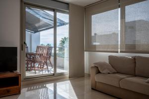 sala de estar con sofá y puerta corredera de cristal en AT119 Nova Torredembarra, en Torredembarra