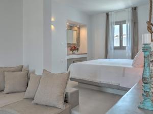 a white bedroom with a bed and a couch at Hotel Papadakis in Naousa