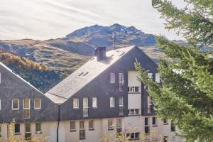 a building with a mountain in the background at Rincón de Anayet | Entrada Autónoma | Formigal in Formigal
