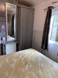 1 dormitorio con cama, espejo y ventana en Haven caravan park Cala gran en Fleetwood