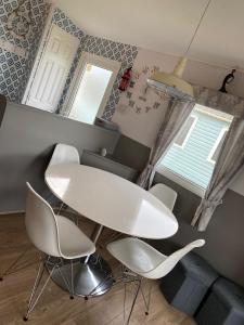 a dining room with a white table and chairs at Haven caravan park Cala gran in Fleetwood