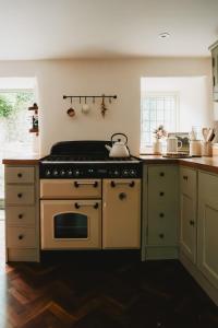 La cocina está equipada con horno y fogones. en Lodge Cottage, Castleton, en Castleton