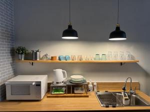 eine Küche mit einer Spüle und einer Mikrowelle in der Unterkunft Hotel art rock in Takamatsu