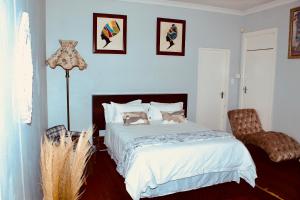 un dormitorio con una cama y una silla en Cozy oasis on Derby, en Johannesburgo