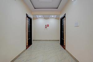 a corridor with doors and a white wall at OYO 19749 New Shelton Suites in Yelahanka