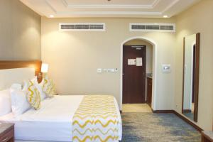 um quarto de hotel com uma cama e uma porta em Taj Al Worood Hotel em Jeddah