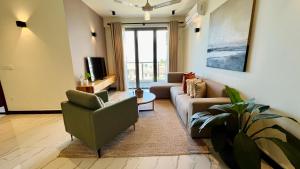 M8 Apartments in Wellawatte في كولومبو: غرفة معيشة مع أريكة وكرسي