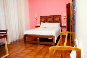 a bedroom with a bed and a pink wall at Onilwe Resort Weligama in Weligama