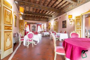una sala da pranzo con tavoli bianchi e sedie rosa di HOTIDAY Hotel Ferrara a Ferrara