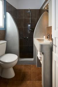 y baño con aseo, lavabo y ducha. en Athiri Santorini Hotel, en Imerovigli