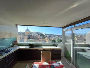 a kitchen with a view of the city from a window at Is- Sienja in Kalkara