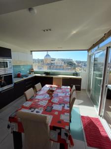 a kitchen with a table with chairs and a view of the city at Is- Sienja in Kalkara +10 photos