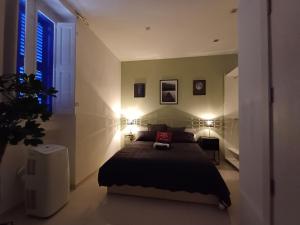 a bedroom with a bed with two lights on it at Is- Sienja in Kalkara