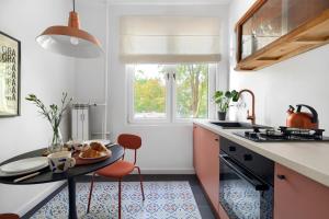 eine Küche mit einem Tisch und Stühlen sowie einem Fenster in der Unterkunft Apartament Szamotulska 59A in Posen