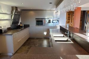a large kitchen with a counter top and appliances at CHALET DE LA COULEE - Chalet de grand standing avec spa offrant une vue sur la vallée in Eyne