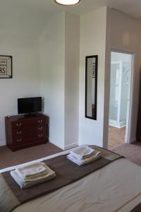 a bedroom with a bed and a dresser with two towels at Markets Tavern Hotel in Brecon