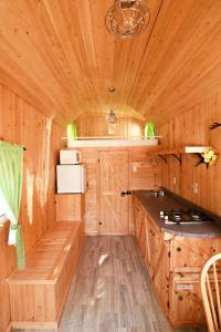 una cocina en una cabaña de madera con fregadero y barra en Waterfront Tiny House near Pomquet Beach en Antigonish