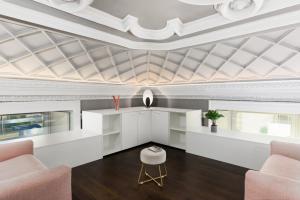 sala de estar con techo artesonado y sillas rosas en Q71 TIMELESS SUITES en Turín