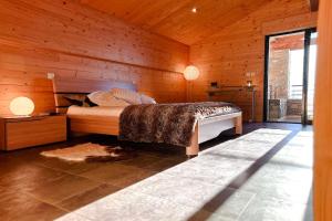 a bedroom with a bed in a wooden wall at CHALET DE LA COULEE - Chalet de grand standing avec spa offrant une vue sur la vallée in Eyne