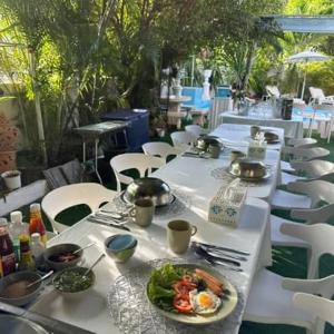 a row of white tables with a plate of food at Villa Bunmark in Sirindhorn +93 photos